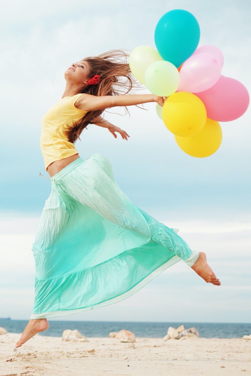 Grab your post-Corona bucket list so you can get to doing what's on that list as soon as possible. You'll feel free again (just like this woman with balloons on a beach).