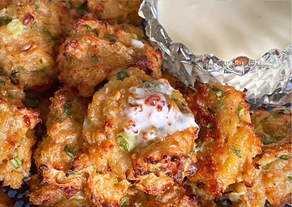 Close up of the warm chicken balls, with homemade gin mayonnaise on the side in a glass dipping bowl