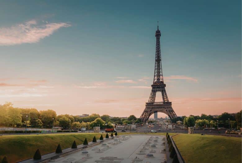 Eiffel Tower, one of the landmarks of Paris and a must-see for first time visitors, even for those receiving cancer treatment. Seen here at sunset with a green park in the foreground.